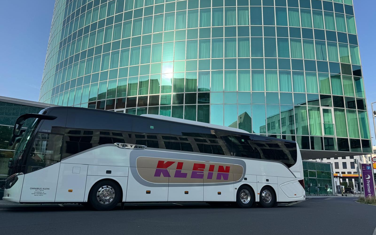 Reisebus von Omnibus Klein vor einer modernen Glasfassade