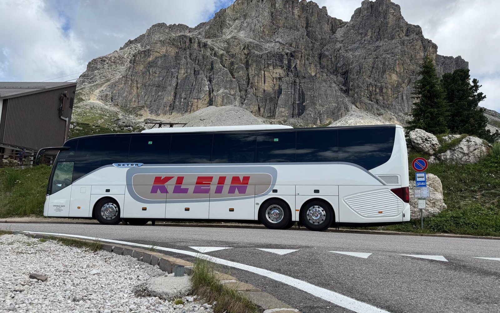 Reisebus von Omnibus Klein vor einer Felswand in den Dolomiten