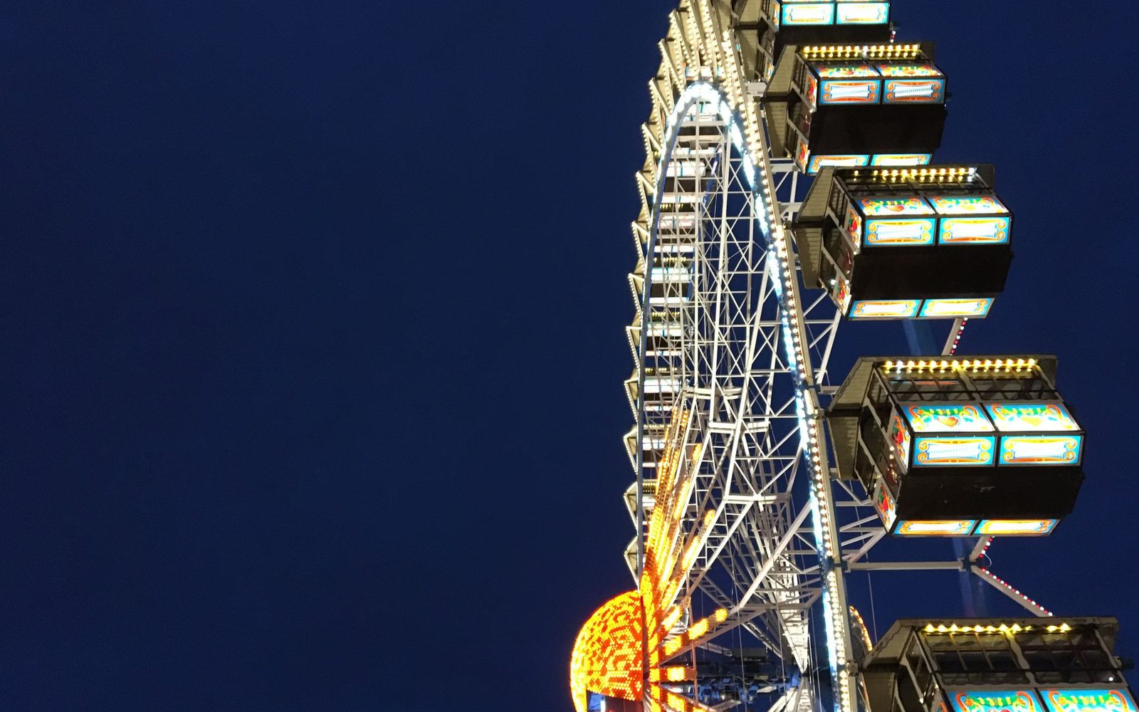 Beleuchtetes Riesenrad auf einem Volksfest am Abend