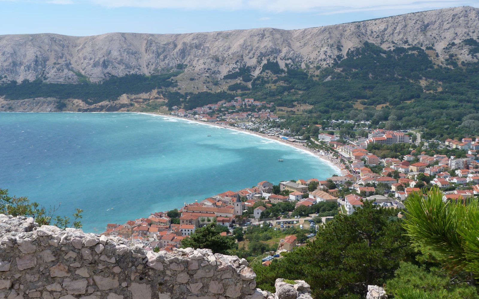 Bucht mit türkisfarbenem Wasser und Ort an der kroatischen Adriaküste