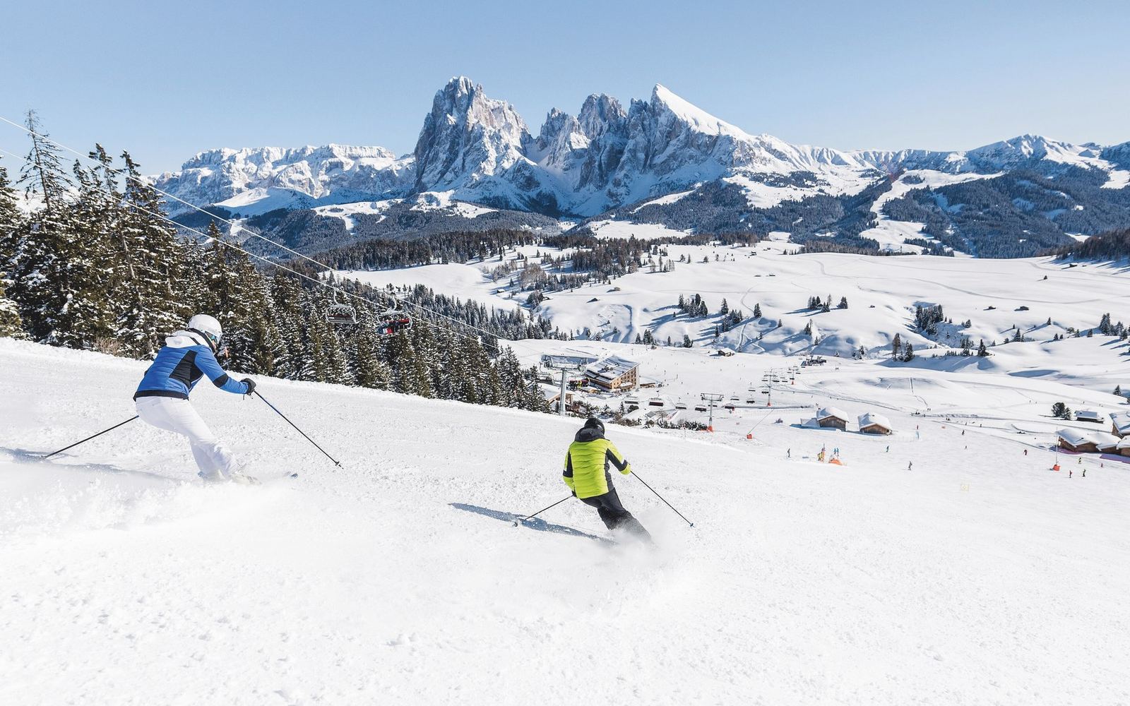Skifahrer auf der Seiser Alm vor Langkofel und Plattkofel